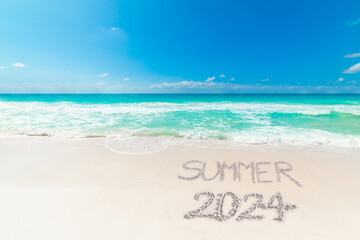 Tropical beach with Summer 2024 written on the sand