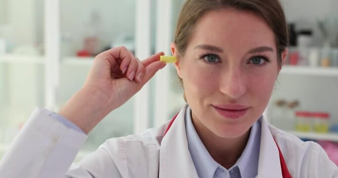 Doctor inserts earplug into ear to minimize noise level