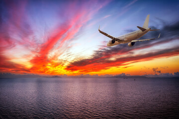 Obraz premium Commercial airliner flying over calm ocean. Travel background