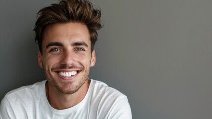 Fototapeta premium Young man with beautiful smile on grey background. Teeth whitening