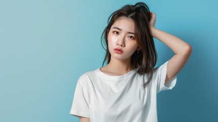 Fototapeta premium Young pretty Asian woman model wearing tshirt looking at camera standing on color background