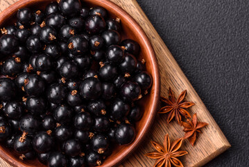 Ripe blackcurrant berries in droplets of water in a ceramic bowl