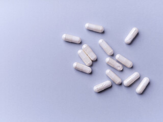 Tyrosine capsules (one of the 20 standard amino acids). A dietary supplement used to improve attention and focus on paper background. Soft focus. Top view. Close up. Copy space.
