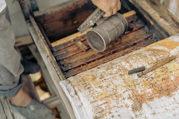 A person is using a metal spoon to stir something in a pan