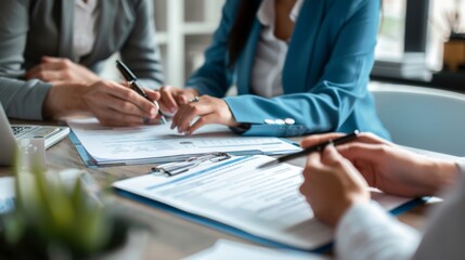 Close-up of business professionals signing documents during a meeting, focusing on hands and paperwork, indicating teamwork and collaboration.