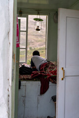 A man is laying on a bed in a room with a window