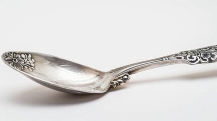 Macro close up of a silver ornamental spoon against a white backdrop