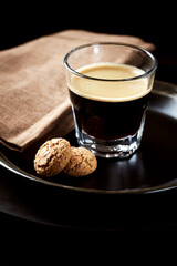 Coffee in glass cup on dark background. Close up. Copy space.