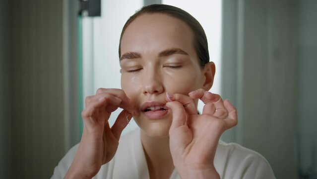 Pretty lady flossing teeth looking camera closeup. Beautiful girl cleaning mouth