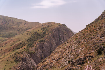 A rocky mountain with a lush green hillside