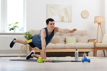 Obraz premium Online fitness trainer. Man doing exercise near laptop at home