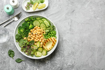 Healthy meal. Tasty vegetables and chickpeas in bowl on grey table, flat lay. Space for text