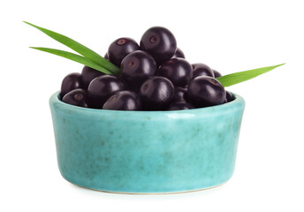 Fresh ripe acai berries in bowl and green leaves isolated on white