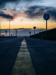 A scenic road at sunset with dramatic clouds and street signs leading into the horizon. sunset in fr