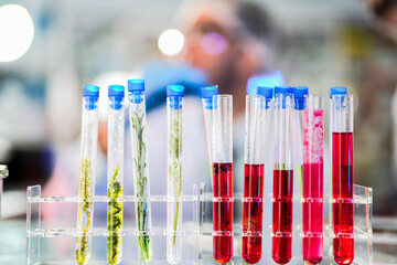 scientific tubes containing rare chemicals and exotic plant samples are used to extract substances...