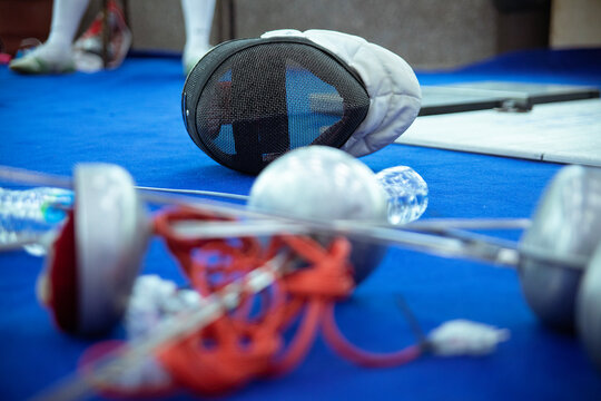 Fencing mask and rapier on floor.
