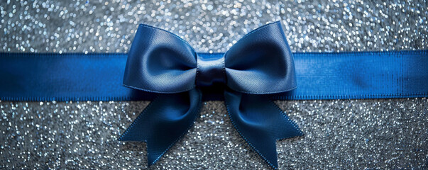 A bright blue ribbon bow on a silver glitter background. The bold color and shimmering texture create a striking and modern look.