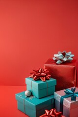 Obraz premium Pile of gift boxes with ribbons on red background. Studio shot for Christmas celebration