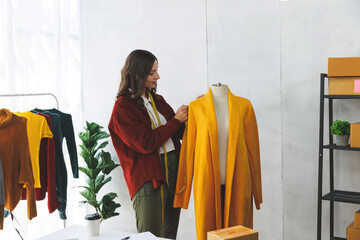 A beautiful woman who owns a clothing brand, she is using a tape measure to sample products. Beautiful woman designer is drafting clothe to sew beautifully according to fashion trend.
