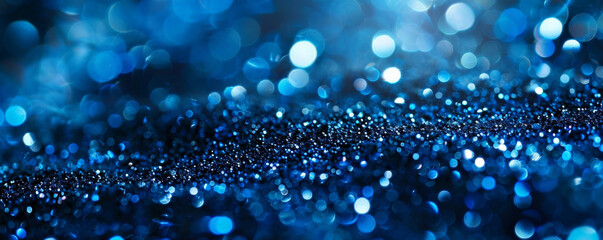 A close-up of blue glitter with selective focus, showcasing the intricate details of the glitter particles while the background fades into a soft, cool blur.