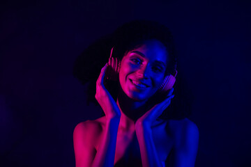 Photo of gorgeous sweet woman nude shoulders earphones enjoy music empty space isolated dark blue color background