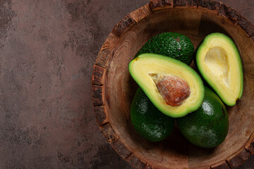 fresh, sliced avocado, in a wooden plate, top view, food background, concept, food styling