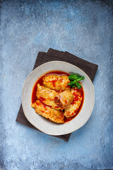 Stuffed cabbage rolls with minced meat, in tomato sauce, top view, without people, in the spotlight.
