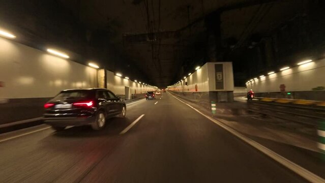 Driver's Point Of View POV from a motorbike on a sunny day driving through the four-lane M30 tunnel from Spain Square to Portugal Avenue with buses, taxis and cars circulating. Driving in Spain tunnel