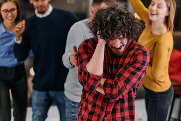 A group of young business people have fun playing interesting games while taking a break from work in a modern office. Selective focus 