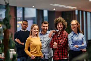 Portrait of successful creative business team looking at camera and smiling. Diverse business people standing together at startup. Selective focus 