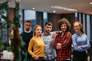 Portrait of successful creative business team looking at camera and smiling. Diverse business people standing together at startup. Selective focus 