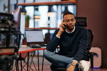 After Hours Reflection: African American Man Using Smartphone in Office.