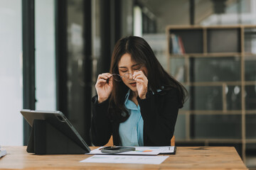 Asian women are stressed while working on laptop, Tired asian businesswoman with headache at office, feeling sick at work, copy space