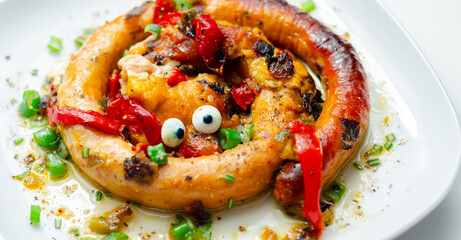 A plate of food with a sausage that has eyes on it