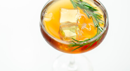 A glass of cocktail with a garnish of rosemary on top