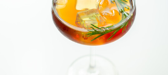 A glass of cocktail with a garnish of rosemary on top