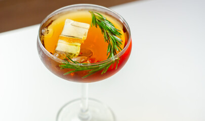 A glass of cocktail with a garnish of rosemary on top