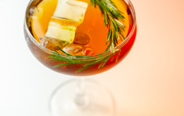 A glass of cocktail with a garnish of rosemary on top