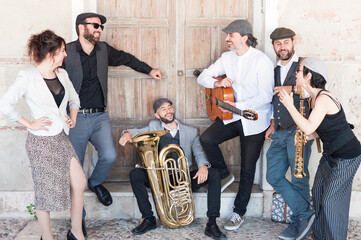 Jazz band playing in the street in broad daylight composed of 6 components