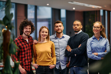 Portrait of successful creative business team looking at camera and smiling. Diverse business people standing together at startup. Selective focus 