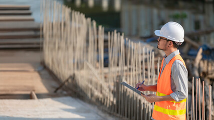 Construction engineer working on a bridge construction site over a river,Civil engineer supervising...