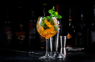 Summer refreshing cocktail drink with cognac, liqueur, sparkling wine with ice and mint in wine...