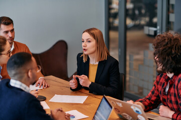 In the vibrant ambiance of a modern startup office, a diverse team of business professionals engage...