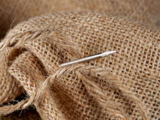 close-up sewing needle on burlap