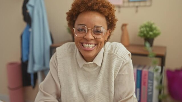 Cheerful african american woman making a hilarious fish face, sitting at home table. crazy, fun-filled comical gesture with lips, expressing pure joy.