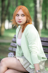 Obraz premium Portrait of a young beautiful red-haired girl in an urban environment.