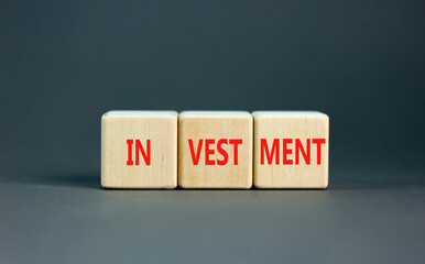 Investment symbol. Concept word Investment on beautiful wooden blocks. Beautiful grey background....
