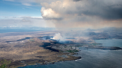 Icelandic landscape with smoke from volcano Grindavik, airial view from the airplane
