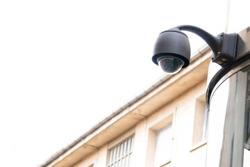 CCTV surveillance camera in the area, security of the streets, face detection. Surveillance camera of urban city. A camera is mounted on a pole in front of a building