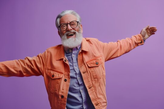 Joyful Senior Man Celebrating with Open Arms. Happy elderly man in orange jacket, glasses, and white beard, joyfully extending his arms against a purple background.